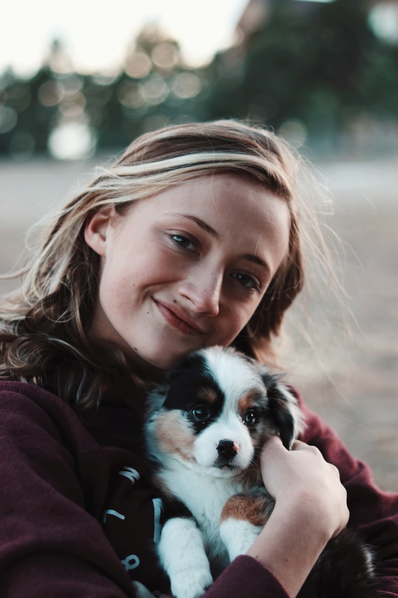 女性が笑顔で子犬を抱きしめる様子
